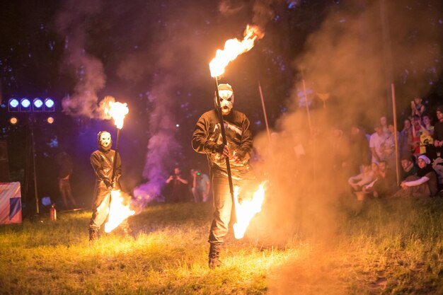 GRODNO BIELORRUSIA JULIO DE 2019 Los artistas callejeros organizan un espectáculo de fuego con fuegos artificiales por la noche