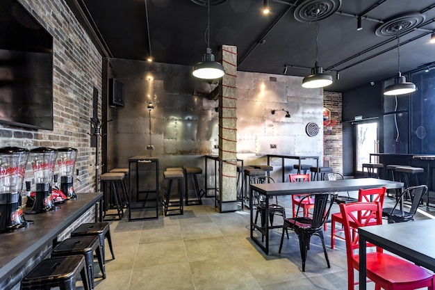 GRODNO BIELORRUSIA MARZO 2019 interior en un moderno bar deportivo de pub con estilo de diseño de loft oscuro con sillas rojas