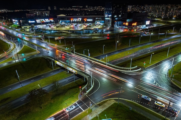 GRODNO BIELORRUSIA NOVIEMBRE 2021 Noche en rotonda en carretera con coches con faros en carretera y luz en ventanas de edificios de varios pisos vida en gran ciudad mirando hacia abajo en el tráfico