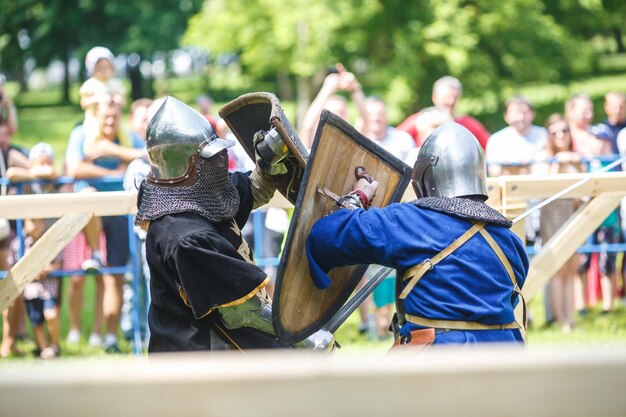 Grodno bielorrússia junho de 2019 cavaleiro medieval luta em capacetes de armadura cota de malha com machados e espadas nas listas reconstrução histórica da luta antiga