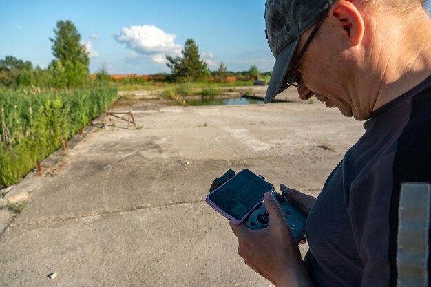 Grodno Weißrussland 10. Juni 2022 Der Pilot eines unbemannten Luftfahrzeugs hält ein Drohnen-Bedienfeld in den Händen Ein Blogger startet während der Fahrt eine Drohne