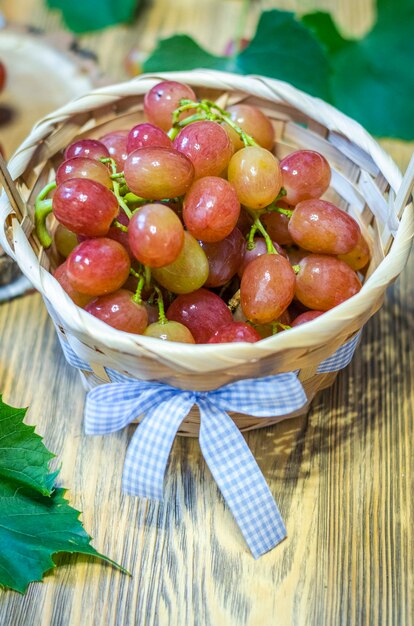 Foto grono de uvas rosadas sobre un soporte de madera