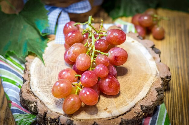 Foto grono de uvas rosadas sobre un soporte de madera