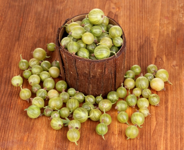 Groselha verde em copo de madeira com fundo de madeira