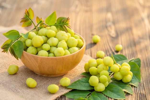 Groselha verde fresca estrela (frutas tropicais tailandesas) em tigela na prancha de madeira