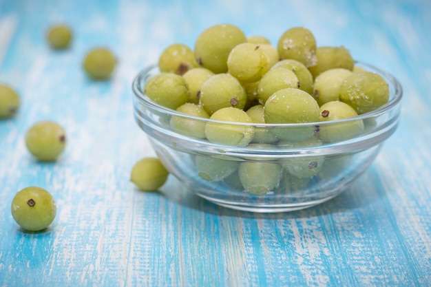 Groselhas de frutas congeladas em uma tigela de vidro na mesa vintage.