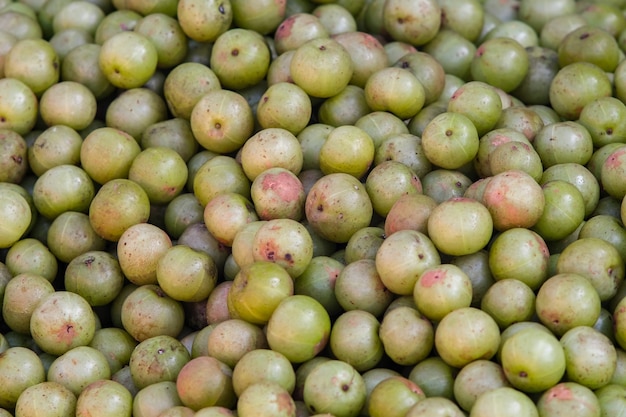 Grosella espinosa india (Phyllanthus emblica), árbol de Malaca o fruta amla. Frutas emblic a la venta en el mercado.