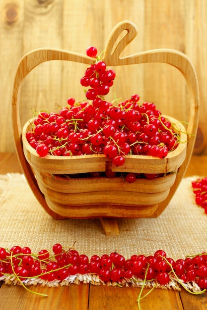 Grosella roja fresca en el florero de madera