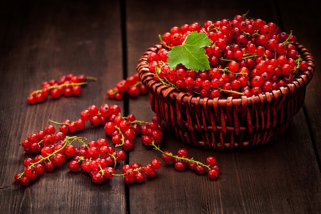 Grosella roja en un recipiente de mimbre sobre la mesa