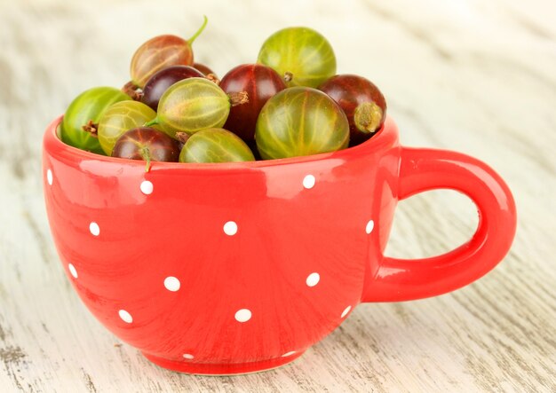 Grosellas frescas en taza en primer plano de la mesa