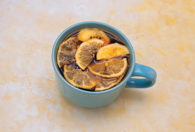 große blaue Tasse mit Tee und etwas Zitronenscheibe