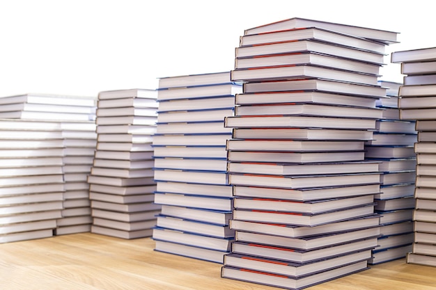 Große Bücherstapel auf einem Holztisch isoliert auf weißem Hintergrund