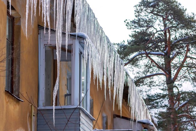 Große Eiszapfen hängen vom Dach eines Wohnhauses Gefahr durch herabfallende Eiszapfen