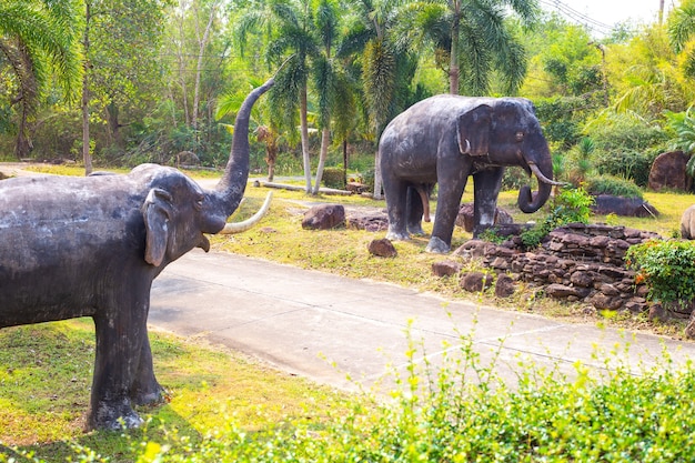 Große Elefanten mit erhobenem Rüssel laufen durch den grünen Dschungel