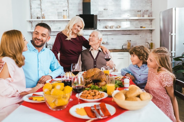 große familie, die zu hause zusammen ein köstliches erntedankessen hat