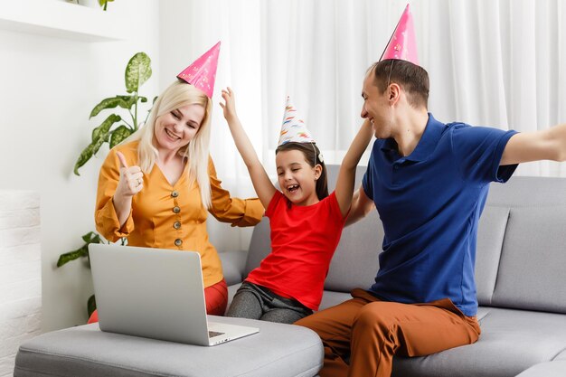 Große Familie feiert Geburtstag online. Mama Papa Kinder zu Hause Laptop Videoanruf Selbstisolation. Party neue Technologie-Gadgets. Coronavirus unter Quarantäne gestellt.