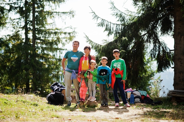 Große Familie mit vier Kindern, die sich in den Bergen ausruhen. Reisen und Wandern mit Kindern.