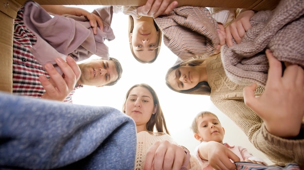 Foto große familie öffnet karton und schaut sich kleidung und dinge an, nachdem sie in ein neues haus eingezogen ist