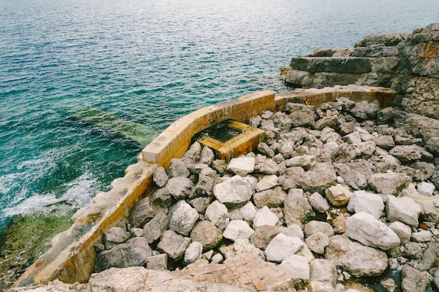 Große Felsbrocken und Reste eines Steinzauns im Meer montenegro