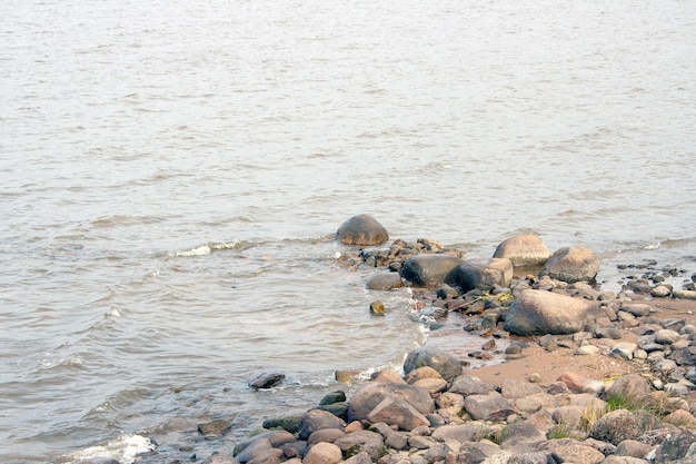 Große Felsen im dunklen Wasser der Bucht an einem kalten bewölkten Tag