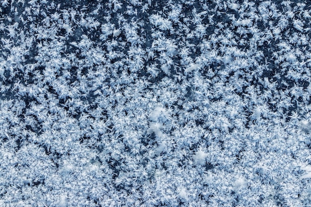 Große, flauschige Schneeflocken auf der Oberfläche des Eises Winter- und Weihnachtshintergrund
