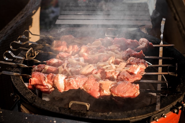 Große Fleischstücke auf dem Spieß liegen auf dem Grill