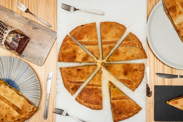 Große geschnittene galizische Empanadas auf einem weißen Tisch