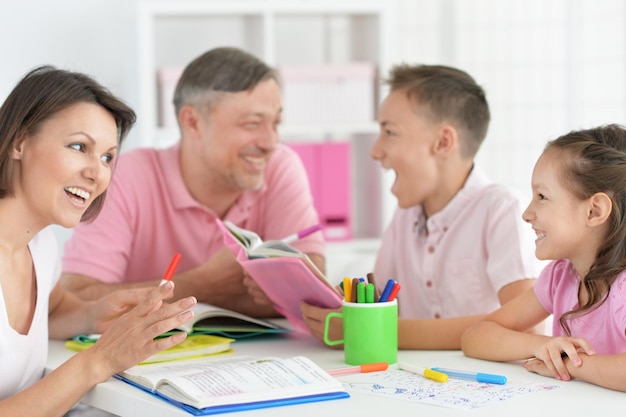 Große glückliche Familie, die Hausaufgaben macht