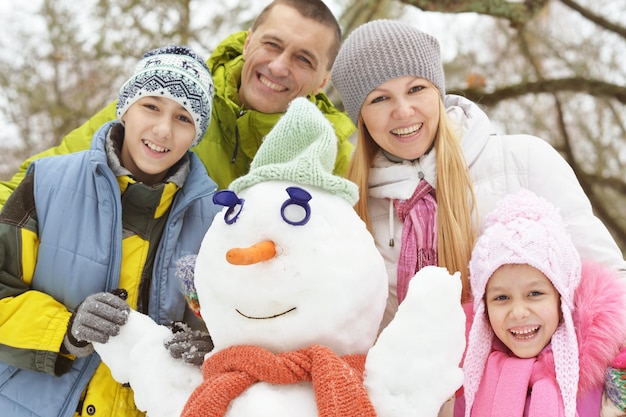 Große glückliche Familie, die Spaß im schneebedeckten Winterpark hat