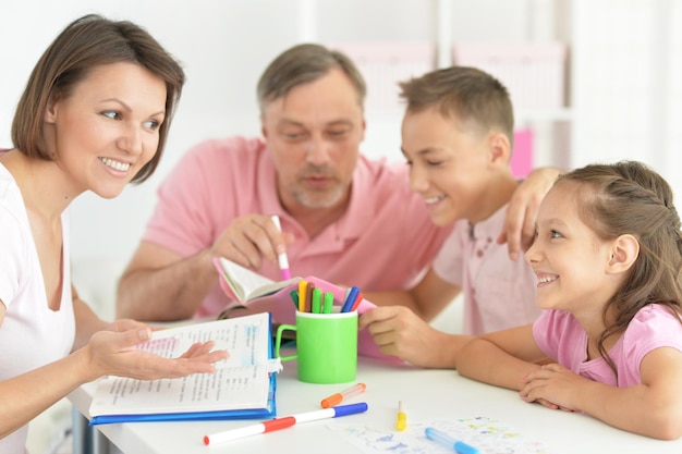 Große, glückliche Familie macht zu Hause Hausaufgaben