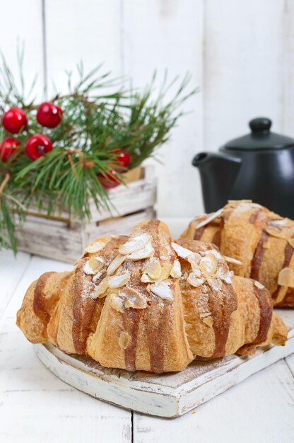 Große leckere Croissants mit Mandelflocken auf weißem Holzhintergrund. Französisches Gebäck. Frühstück.