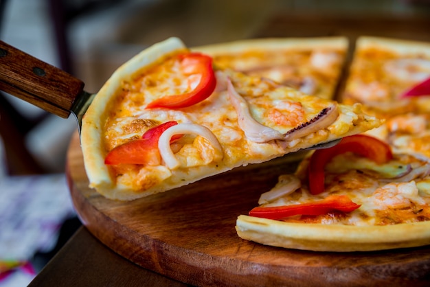 Große Pizza auf einem Holztisch.