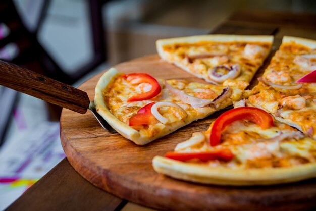 Große Pizza auf einem Holztisch.