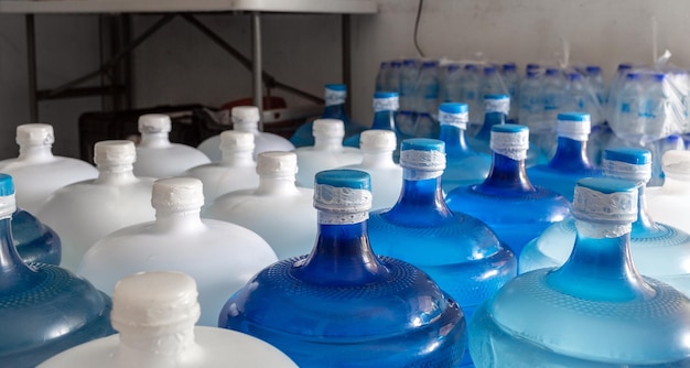 Große Plastikflaschen oder weiße und blaue Gallonen gereinigtes Trinkwasser im Inneren des Produkts