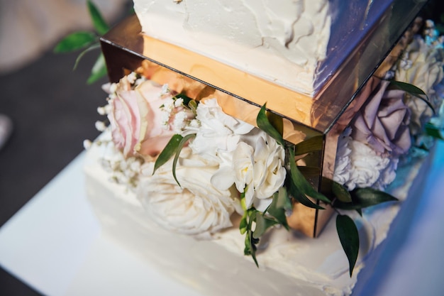 Foto große quadratische hochzeitstorte mit drei etagen vor dem hintergrund der led-beleuchtung premium-hochzeit in der ukraine