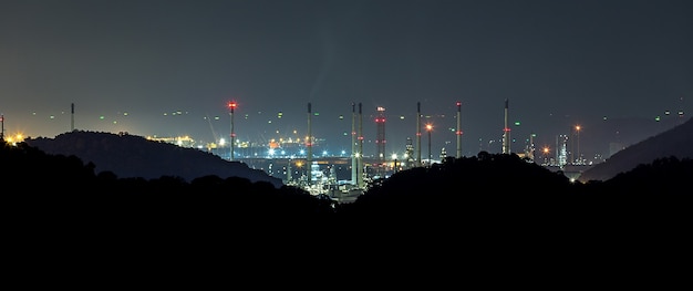 Große Raffinerie hinter dem Berg in der Nacht