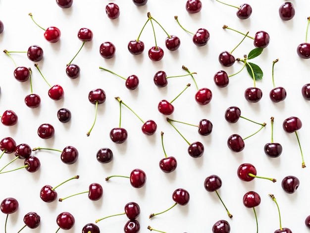 Große reife Kirschbeeren mit Blättern und Tropfen des Wasserhintergrundes. Natürlicher Sommerlebensmittelhintergrund.