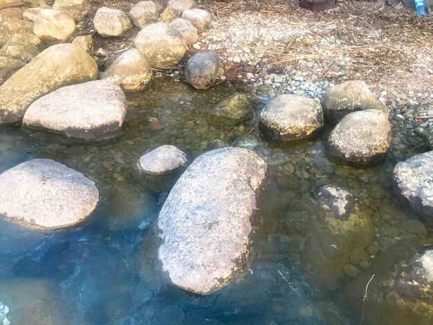 Große runde schöne Natursteine Kopfsteinpflaster im Wasser Meer See Fluss Hintergrundtextur