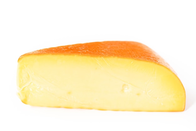 Große Scheibe geräucherter Gouda-Käse auf weißem Hintergrund.