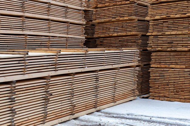 Große Stapel Holzbohlen Hintergrund mit selektivem Fokus und linearer Perspektive Winter im Freien