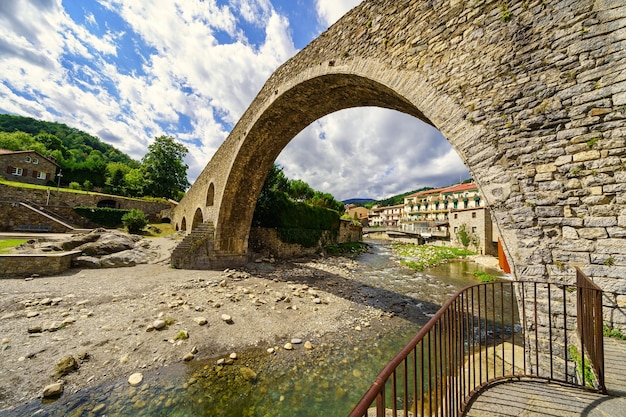 Große Steinbrücke mit riesigem Bogen über den Fluss Ter, der durch die antike Stadt Camprodon Girona Spanien führt