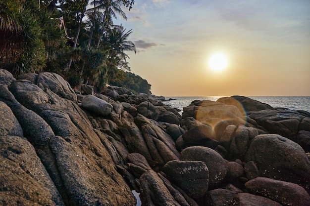 Große Steinpalmen beruhigen das Meer und die Sonne bei Sonnenuntergang in Thailand