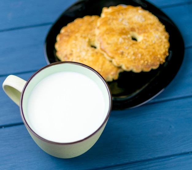 Große Tasse mit Milch und Keksen im Hintergrund