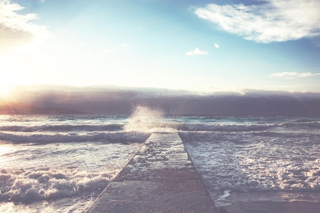 Große Wellen, die bei stürmischem Wetter auf dem Steinpier zermalmen