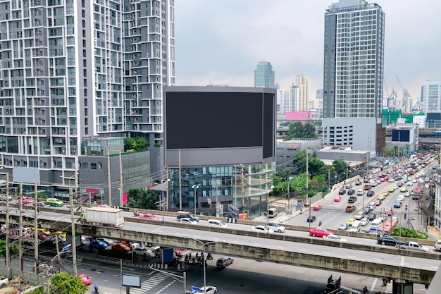 Große Werbetafel am Gebäude mit überfülltem Verkehr in Bangkok