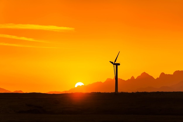 Große Windkraftanlagen in der Wüste gegen Berge