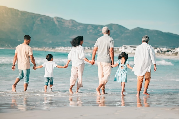 Großeltern, Eltern oder Kinder halten sich am Strand als große Familie an den Händen, um gemeinsam in den Urlaub zu reisen. Großvater, Großmutter oder Rücken der Mutter, die mit Papa spazieren gehen, oder Kinder auf See, um sich zu entspannen