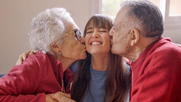 Großeltern küssen ihre Enkelin, während sie sie besucht