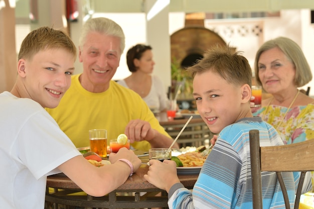 Großeltern mit Enkel beim Frühstück im tropischen Resort