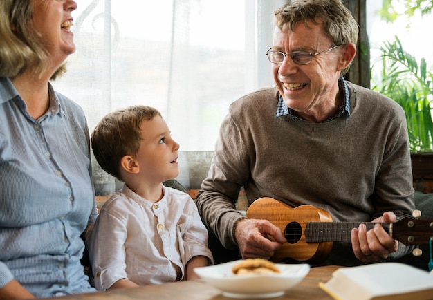 Großeltern mit Enkel, die Spaß mit Ukelele haben